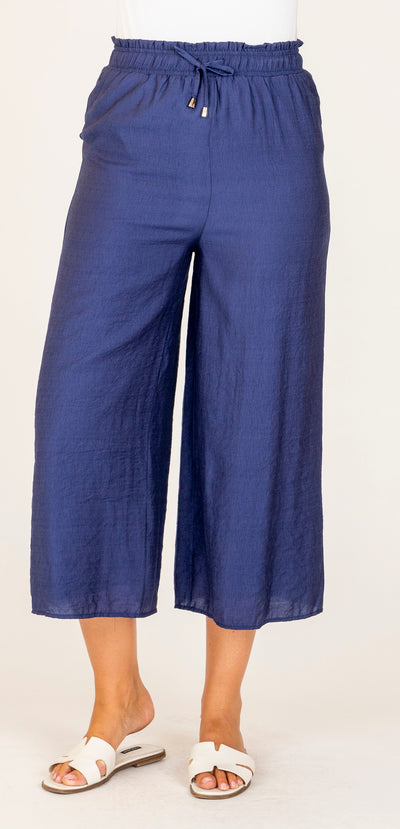 Woman wearing Serena Pants in cobalt blue by Renoma – lightweight cropped pants with elastic waist, styled for spring.