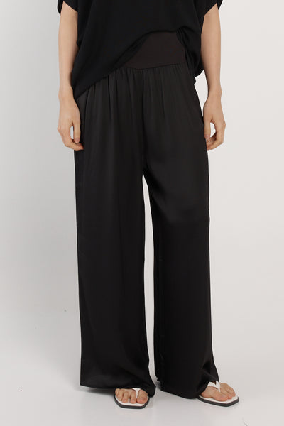 Front view of model wearing Dashing Pant Black by Fate+Becker, wide-leg silk blend pants with flat elastic waistband.