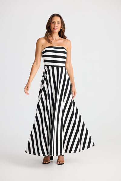 Model wearing the Brave+True Thandie Strapless Dress in black wide stripe, front view with flared skirt.