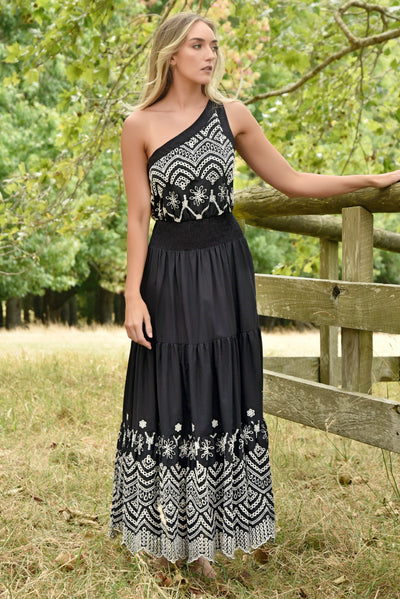 Model wearing Always On My Mind black embroidered one-shoulder dress with shirred waist and tiered skirt – front view