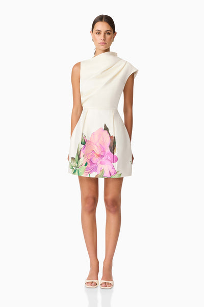 Woman wearing the Azelie dress with floral design on a white background