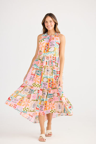 Model wearing the Margot Dress Sardinia Summer by Holiday – sleeveless midi dress with gathered neckline, loose fit, and colourful Italian-inspired print, styled with white sandals.