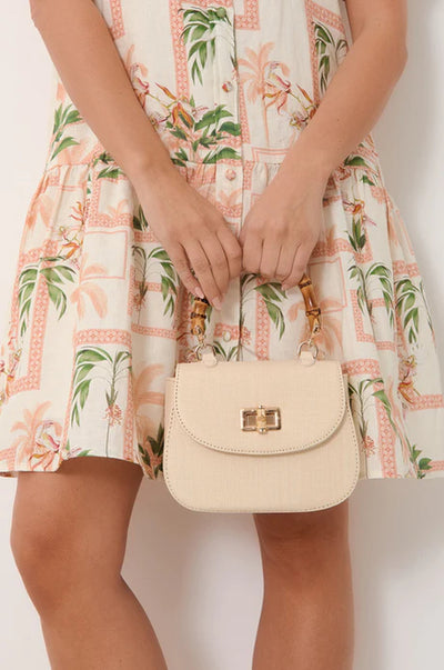 Marissa Woven Bamboo Curved Mini Bag Cream – model holding cream mini handbag with bamboo handle