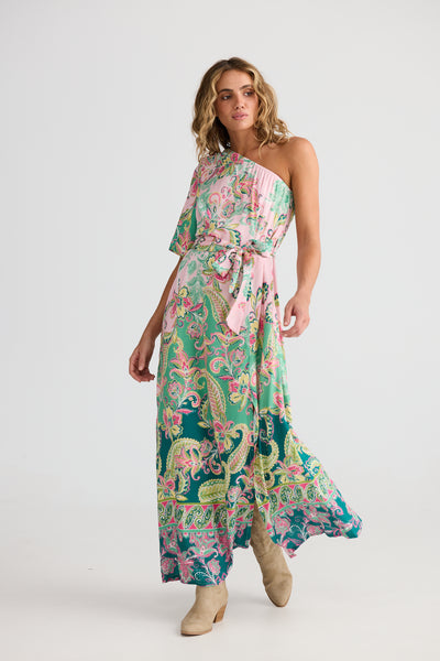Woman wearing the Cantina Asym dress with a pink belt on a white background