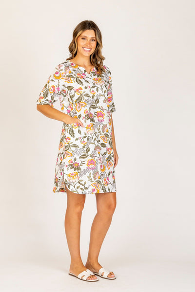 Model wearing the Ava Floral Dress from Maglia – knee-length shift dress with short sleeves, side pockets, and a vibrant multicolour floral print on a white background, perfect for spring and summer.