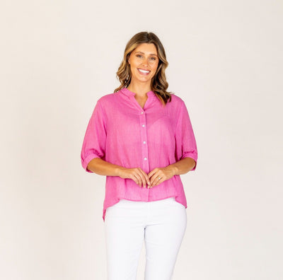 Front view of Maglia Bella Shirt in vibrant fuchsia with half sleeves, button front, and white pants.