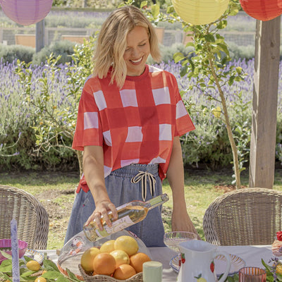 Model styling the Elm Edin Tee outdoors at a summer table setting