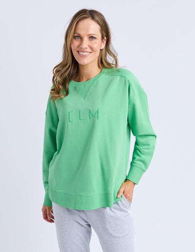 Woman wearing Elm Established Crew in spring green, front view.