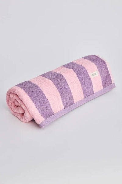 Holiday Porter Beach Towel in pink and purple stripe, rolled up on white background