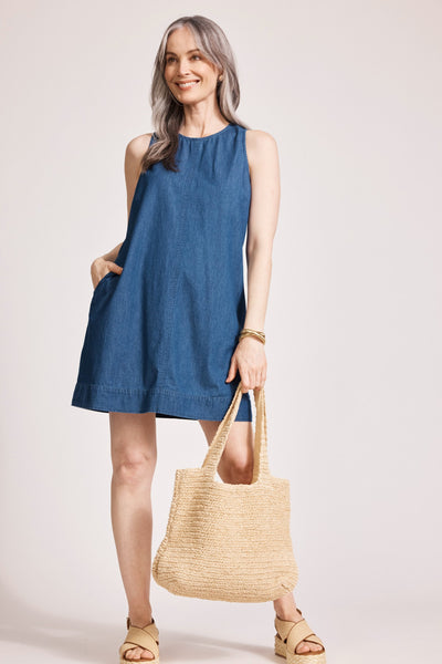 Model wearing Melenia Denim Dress with hand in pocket and carrying bag