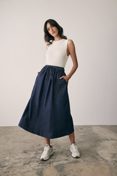 Revival Denin Skirt front image on model with arms in pockets. 