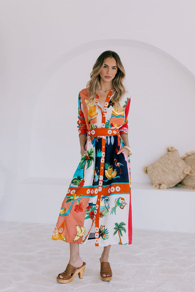 Model wearing San Sabastian midi shirt dress in vibrant tropical print, front view.