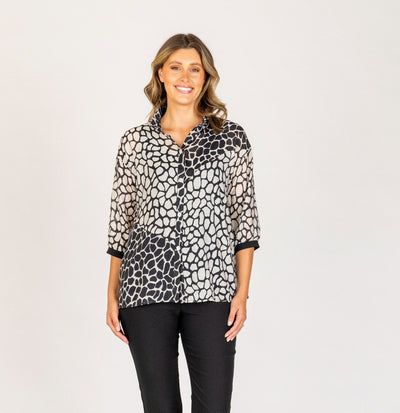 Velora Shirt in black and white abstract print by Renoma sheer fabric, worn with black pants.